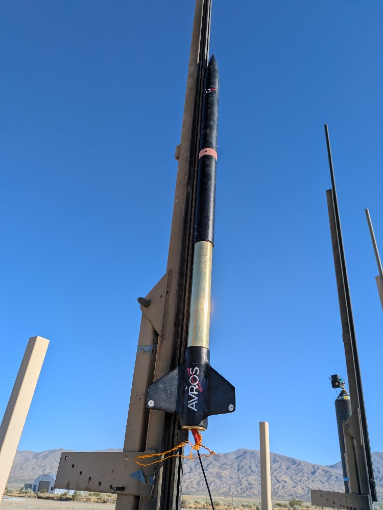 AVROS MonoTube prototype mounted vertically on a launch rail against a clear blue sky